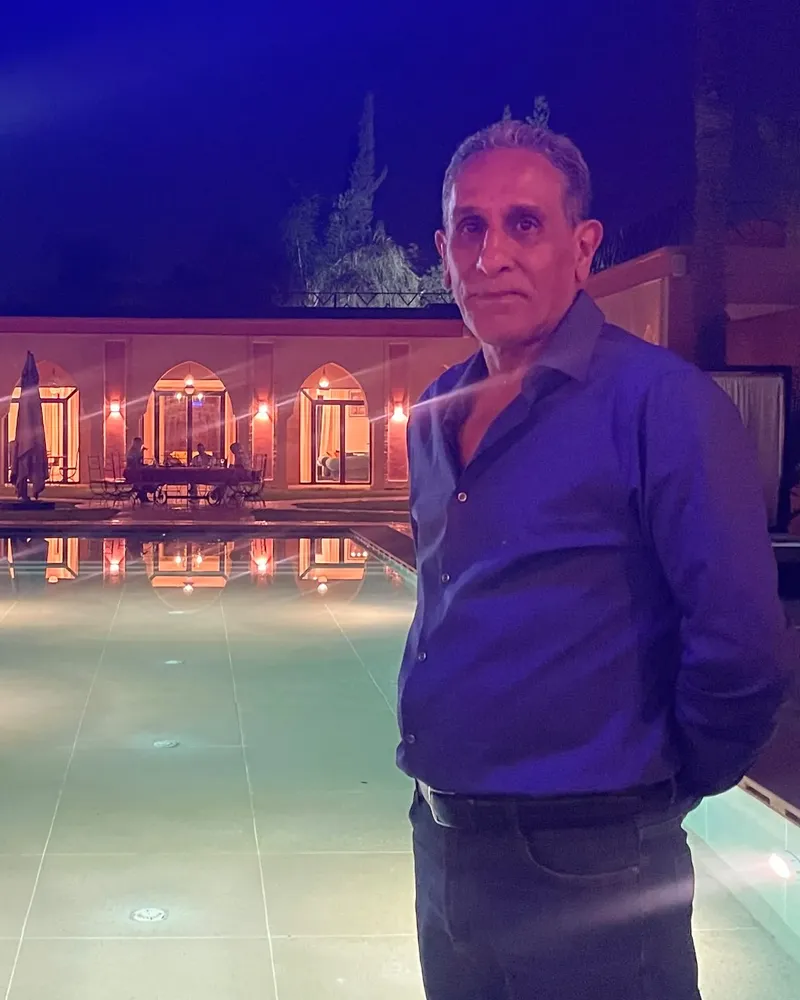 Sakine Meliani beside a lit riad pool at night, 2026